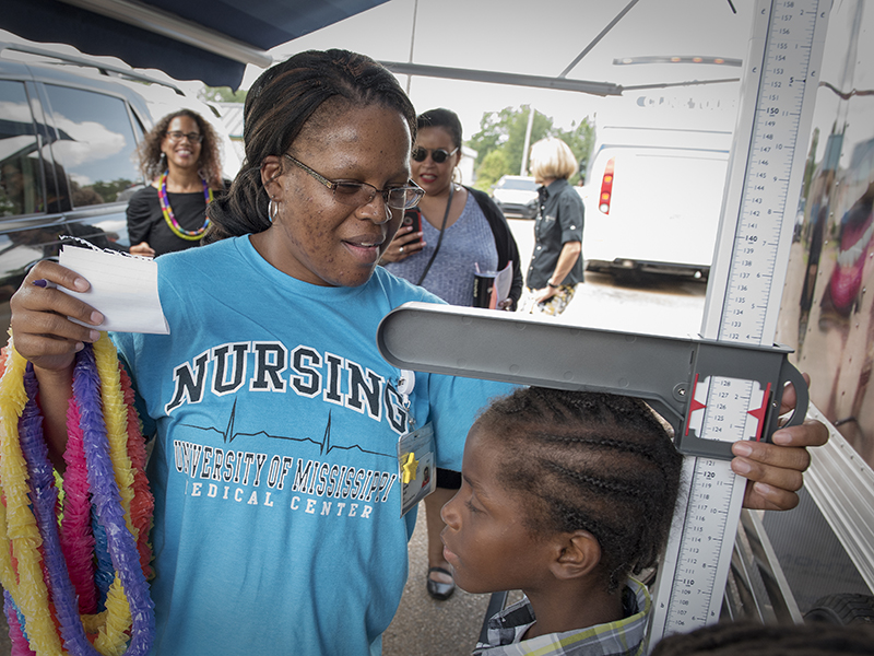 Ramona Brock, a licensed practical nurse with the School of Nursing's Delta school-based clinics, checks the height of George Gilliam of Jonestown.